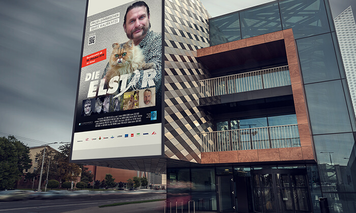 Plakat-Wand mit Ankündigung des Kino-spots "Elster trifft Raubkatze"