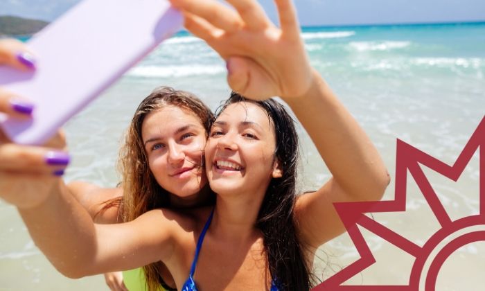 Zwei Mädchen am Strand machen ein Selfie mit ihrem Smartphone